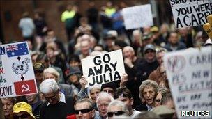 Protesters hold a banner against Australian Prime Minister Julia Gillard during a rally against a carbon tax in central Sydney July 1, 2011