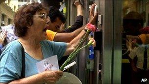 Demonstrators bang on the door of the branch of Banco Frances in the financial district of Buenos Aires, 6 February 2002.