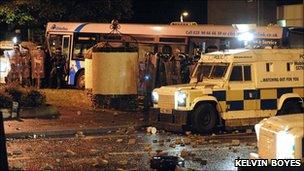 PSNI officers and vehicles beside Translink bus