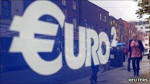 Pedestrians walk past a discount store on Moore Street in Dublin