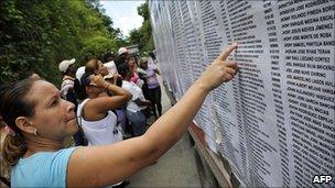 A relative of an inmate of El Rodeo I penitentiary points at a name on the list of inmates, in Guatire, outskirts of Caracas, June 21, 2011.