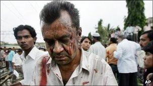 An injured man walks away from Mahim railway station following explosions on the rail network in Mumbai, India, 11th July 2006