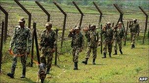 Indian Border Security Force soldiers patrol along the India-Bangladesh border at Fulbari on 17 April 2011