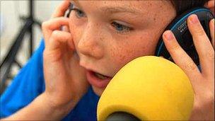 Visitor to the BBC East Midlands roadshow has a go at reading the news in 2009