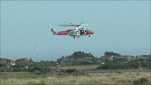 Solent Coastguard helicopter rescuing a cyclist who got stuck in mudflats at East Head, Chichester Harbour, West Sussex in July last year