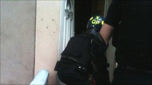 A police officer breaks down a door