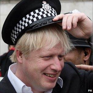 London Mayor Boris Johnson wears a policeman's hat in Trafalgar Square