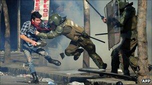 A student is arrested by riot police during a protest against the government of President Sebastian Pinera and a new education law, in Santiago on 14 July 14