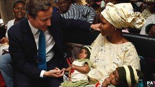 David Cameron chats to a mother of twins at a clinic in Lagos