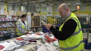 Postal workers sorting mail