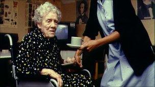 A nurse helping an elderly woman in a wheelchair