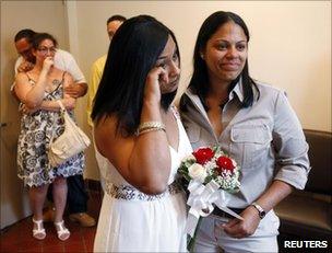 Same-sex couple Mishan Moore (L), 39, wipes a tear as her partner Jacqueline Rodriguez, 34, looks on during their wedding ceremony at Queens Borough Hall in New York, 24 July