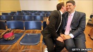 A gay couple embrace on their wedding day at the Brooklyn City Clerk's office in New York, 24 July