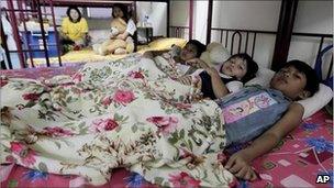 June 8, 2011 photo, Myanmar refugees share a bed in their room in a suburb of Kuala Lumpur, Malaysia