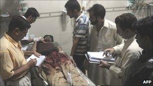 Paramedics treat an injured man in a Karachi hospital