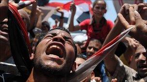 Egyptian protesters wave their national flag and shout slogans as thousands crowd Cairo's landmark Tahrir Square on July 15, 2011 to demand political change as anger grows with the military rulers over the slow pace of reform.