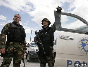 Kosovan policemen stand beside a vehicle in Mitrovica, 26 July