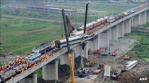 This photo taken on July 24, 2011 shows workers clearing wreckage of mangled carriages after a Chinese high-speed train derailed