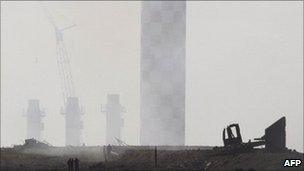 Debris lies in front of a power plant chimney