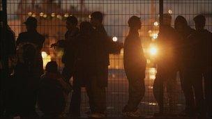 Asylum seekers standing at the port of Calais, France