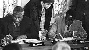 Joshua Nkomo (L) and Robert Mugabe (R) sign the Rhodesia ceasefire agreement at Lancaster House in London in 1979