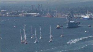 The yachts leave Southampton with HMS Illustrious in the background