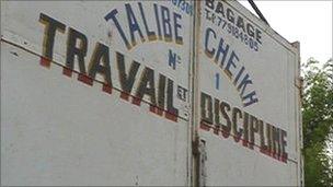 The Mouride motto 'Work and Discipline' painted on the back of a lorry