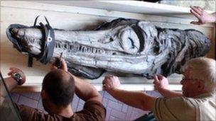 Museum staff unload the fossil which is on load from the Natural History Museum in London.