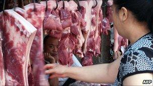 A Chinese customer selects pieces of pork at a market in Yichang, central China's Hubei province