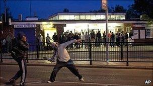 Man throws a missile during rioting in Enfield