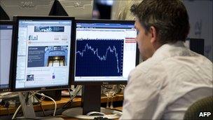 Trader on the Amsterdam stock exchange watches market movement on 8 August 2011