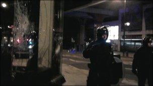 Riot police next to a smashed shop window. Copyright: Emma Reynolds and Ailsa Leslie.