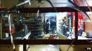 Youths use aerosol cans to set fire to shelves of goods inside a retail store on Tottenham High Road after youths protested against the killing of a man by armed police in an attempted arrest on August 6