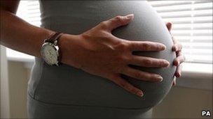 A pregnant woman holding her stomach