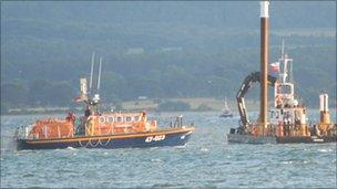 The all-weather lifeboat along with the specialist lifting vessel in Poole harbour