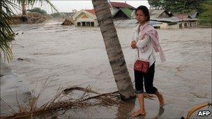 Cambodian woman walking from her house that flooded by water and sand at a village on Boeng Kak lake November 8, 2010