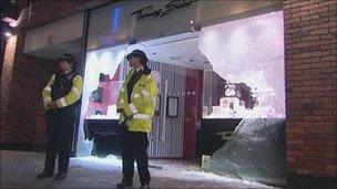 Two police officers guarding a shop