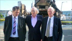 Maurice Reeves with his two sons i front of his burnt out shop