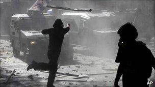 Demonstrators attack a police vehicle during riots after a student protest in Santiago, Chile