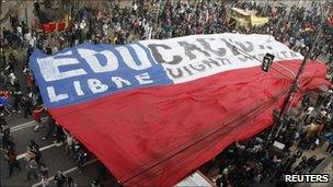 People carry a huge Chilean flag during a rally in Valparaiso to demand changes to the education system