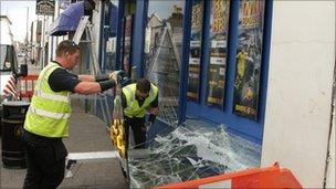 Workers fixing broken window of a Coral bookmakers shop in Barton Street, Gloucester