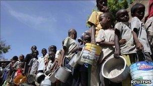 Internally displaced children queue to collect food relief from the UN World Food Programme (WFP) at a settlement in the capital Mogadishu on 7 August 2011