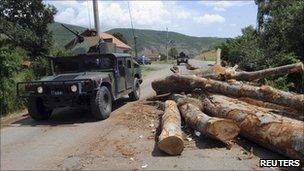 K-For troops pass a blockade in the village of Zupce near the border between Kosovo and Serbia.