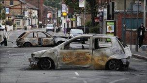 Burned out shells of cars block a road in Toxteth