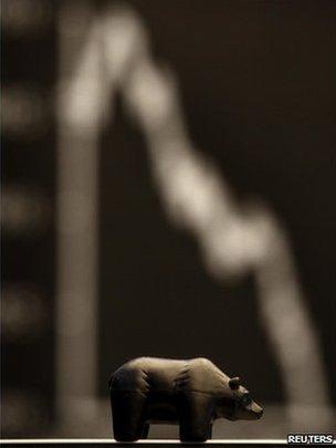 A figure of a bear, symbol for down going bourse trade, is seen in front of the German share price index at Frankfurt's stock exchange