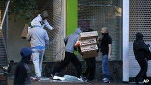 Looters take electrical goods from a shop in Birmingham. Photo: 9 August 2011