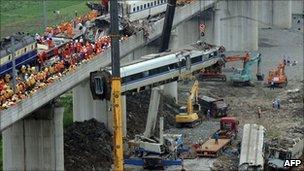 Workers clear wreckage of mangled carriages after a Chinese high-speed train derailed, July 24, 2011