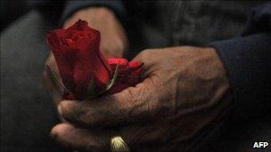 A relative of a civil-conflict victim holds a rose on 2 August 2011 in Guatemala City