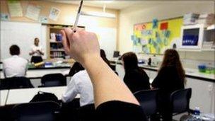 Pupil putting up hand in classroom