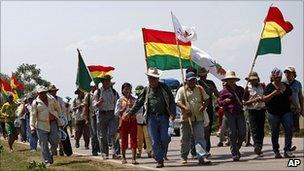 Bolivian indigenous marchers carrying flags on the road from Trinidad to La Paz